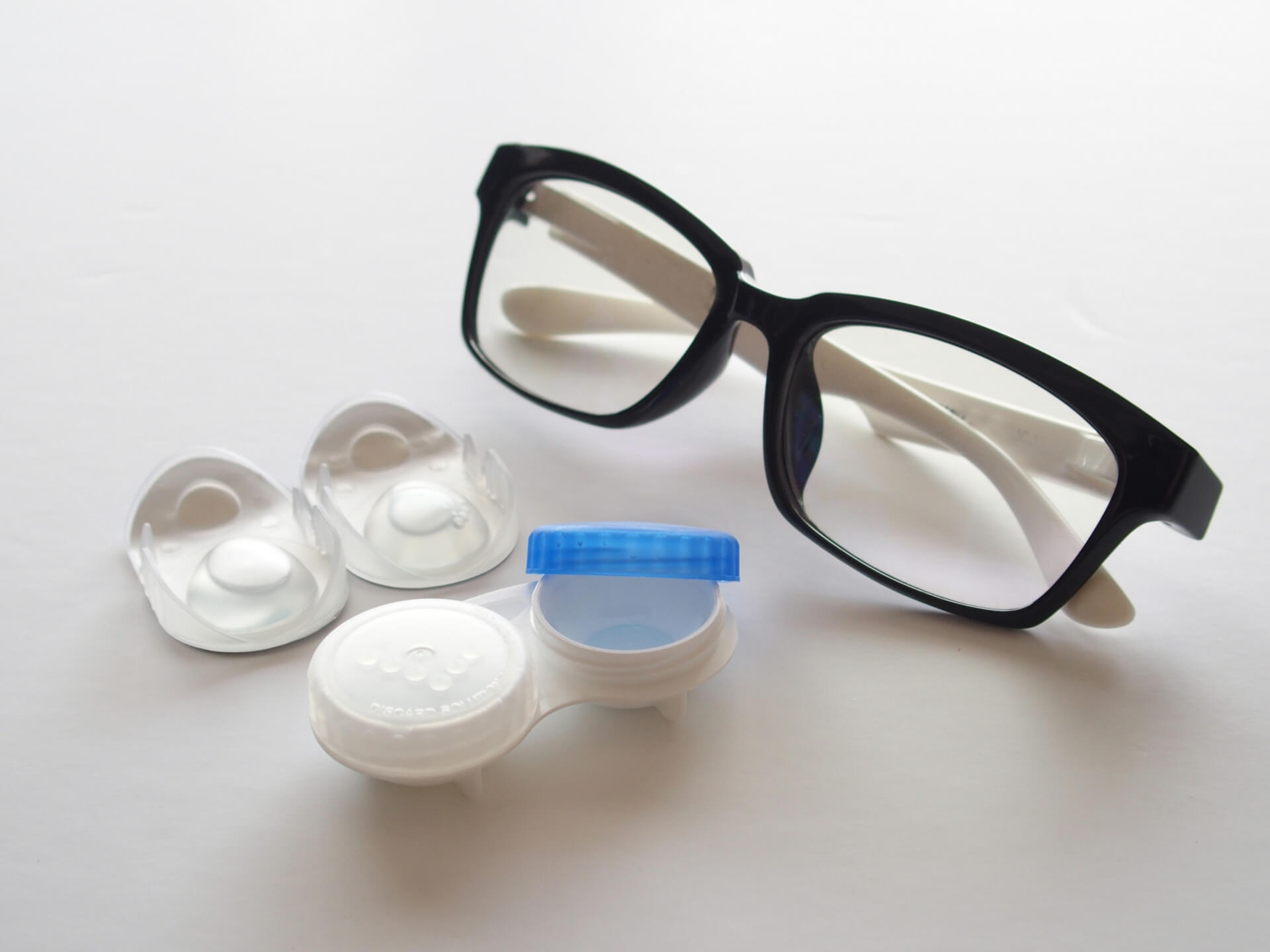 机の上に置かれたメガネとコンタクト容器